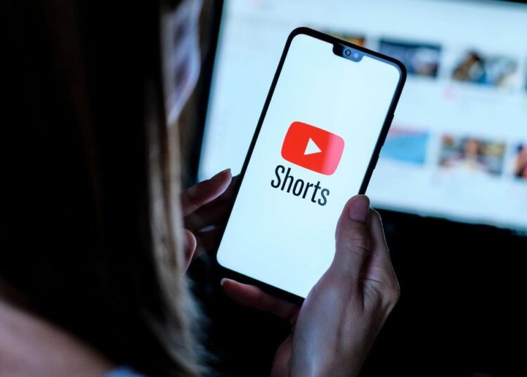 Stafford / United Kingdom - September 14 2020: Youtube Shorts app logo seen on the smartphone which hold by young girl. It is a new short looping video  app, competitor to TikTok, Bytes and Reels.